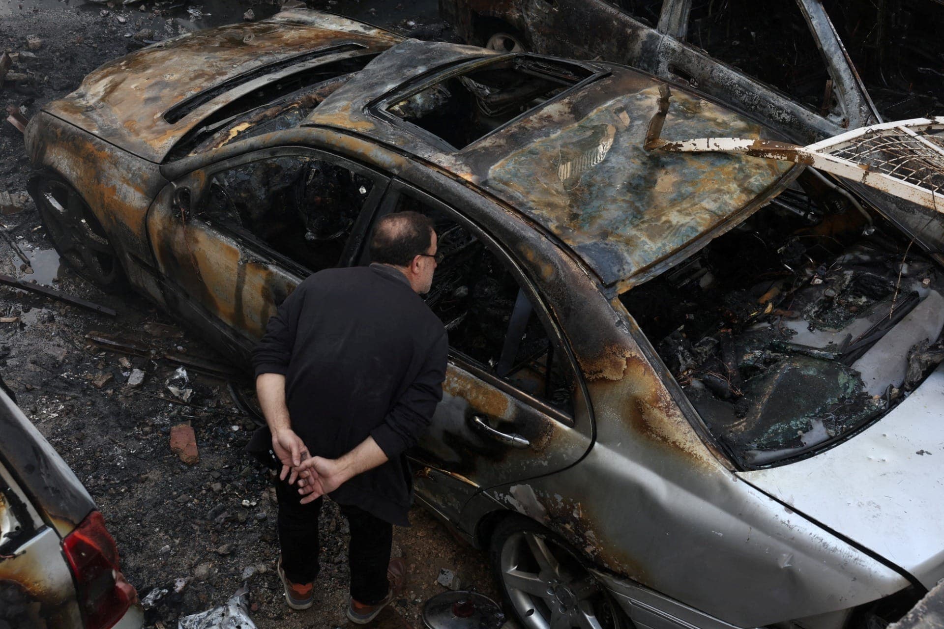 Homem observa veículo queimado após ataque israelense em Beirute, no Líbano