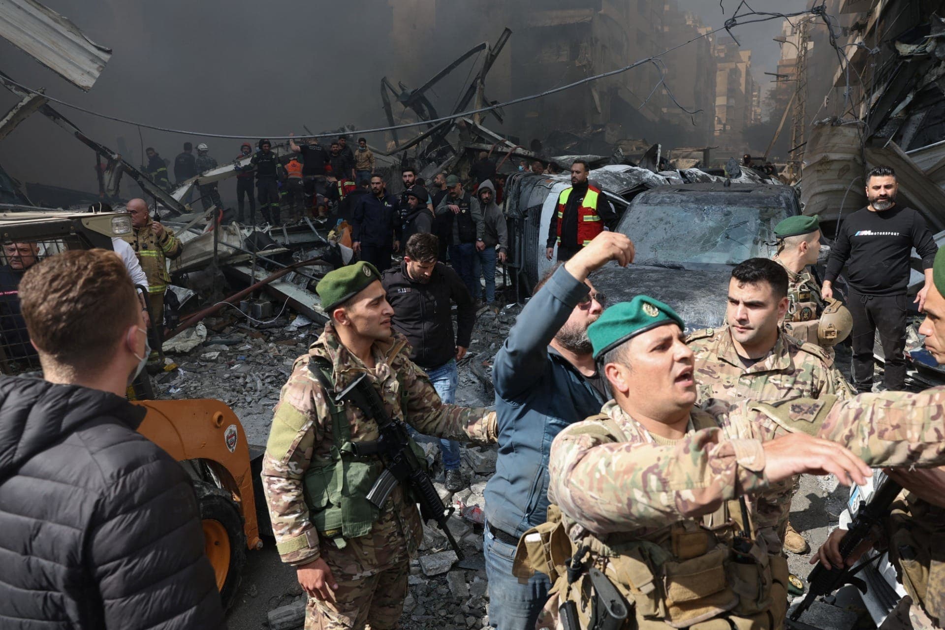 Pessoas se reúnem enquanto socorristas e soldados do exército libanês trabalham no local de um ataque israelense em Beirute, no Líbano