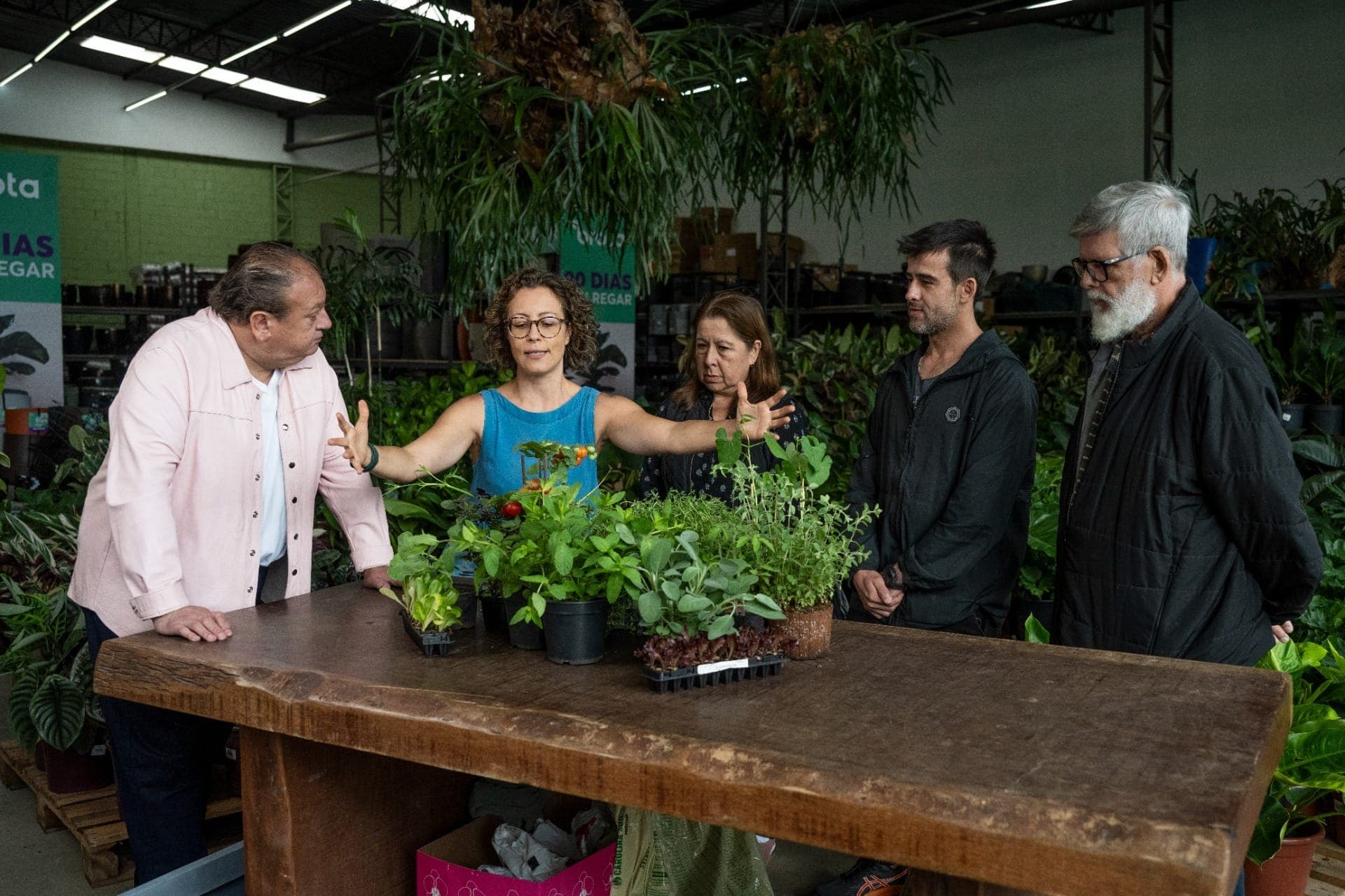 Carol convida os visitantes a colocarem as mãos na terra, fazendo um paralelo entre cuidado e estrutura.