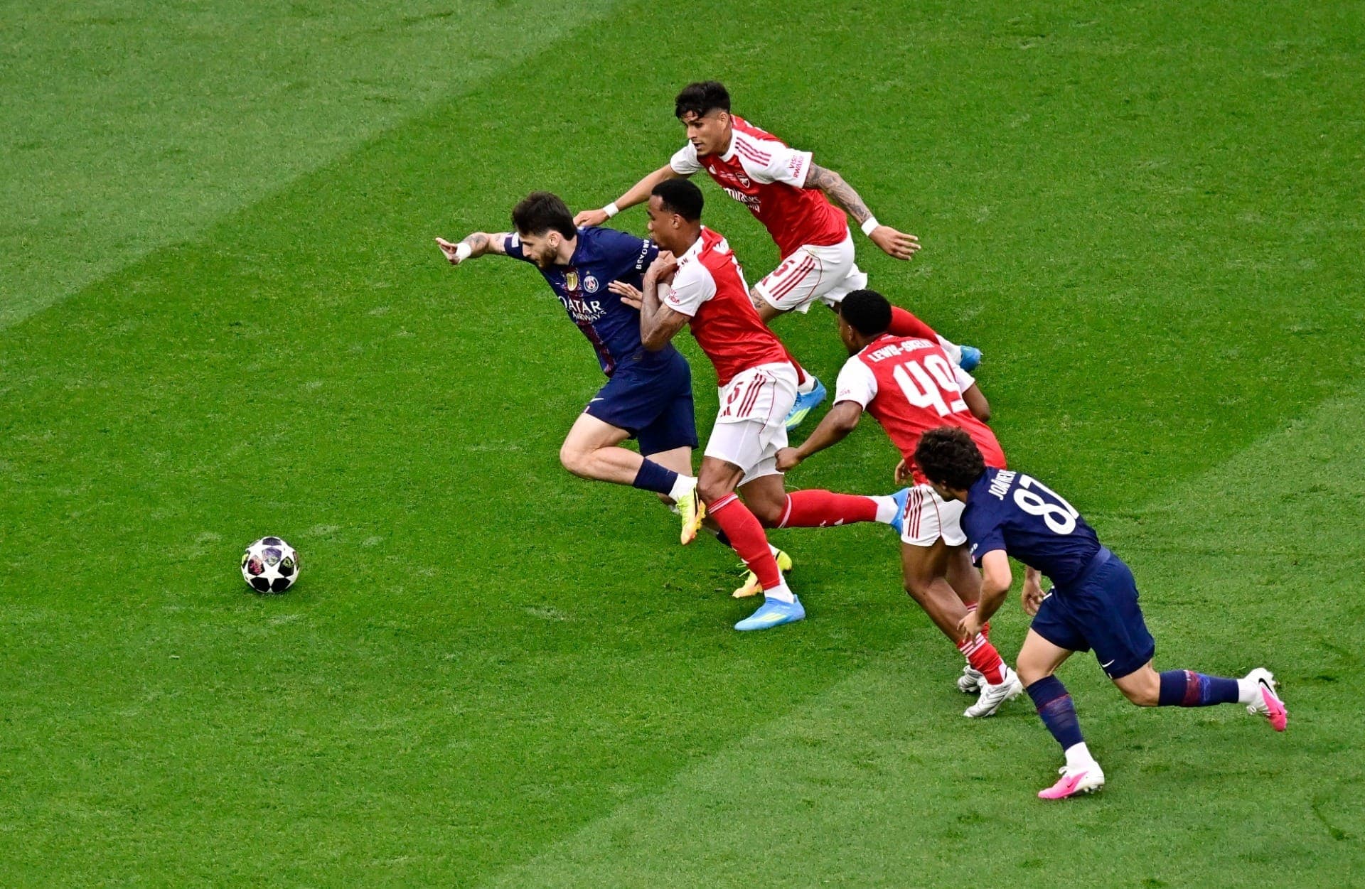 Khvicha Kvaratskhelia, do Paris Saint-Germain, em ação contra Gabriel Magalhães e Piero Hincapié, do Arsenal