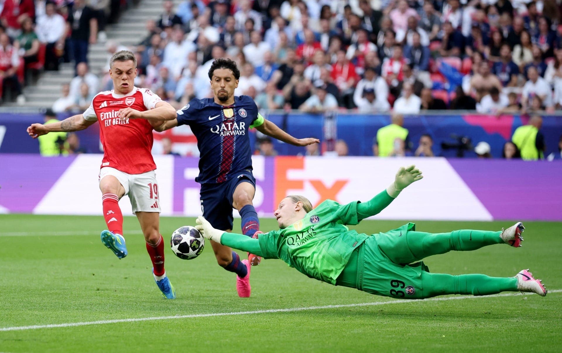 Matvey Safonov se choca com Marquinhos em disputa com Leandro Trossard, do Arsenal