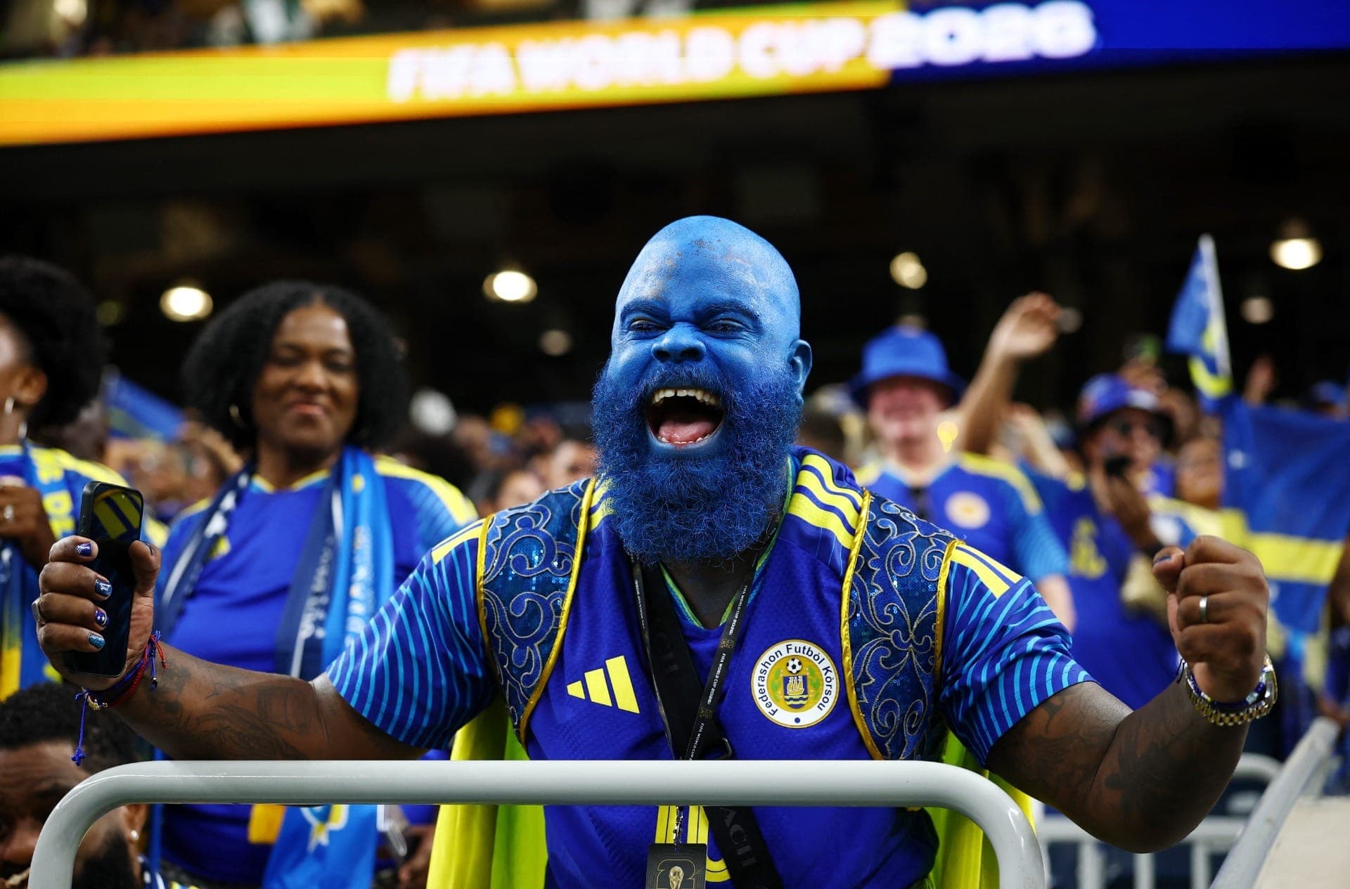 Torcedor de Curaçao, pintado de azul, celebra a primeira participação do país na Copa.
