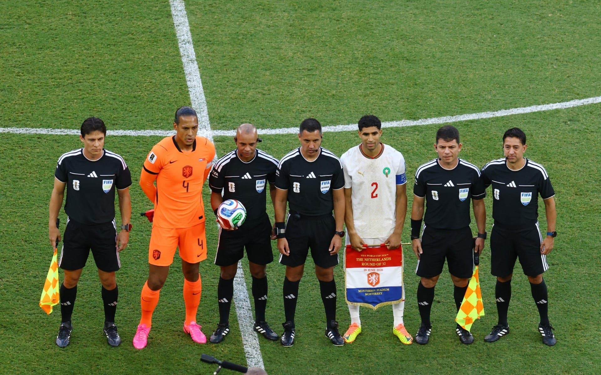 Virgil van Dijk, da Holanda, e Achraf Hakimi, do Marrocos, posam para uma foto ao lado dos árbitros antes da partida.