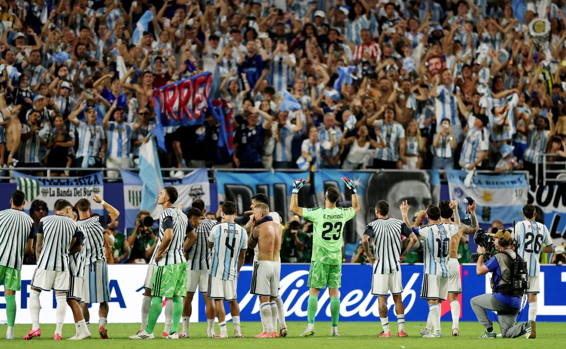 Jogadores e torcedores da Argentina comemoram após a partida, garantindo a classificação da Argentina para as oitavas de final da Copa do Mundo.
